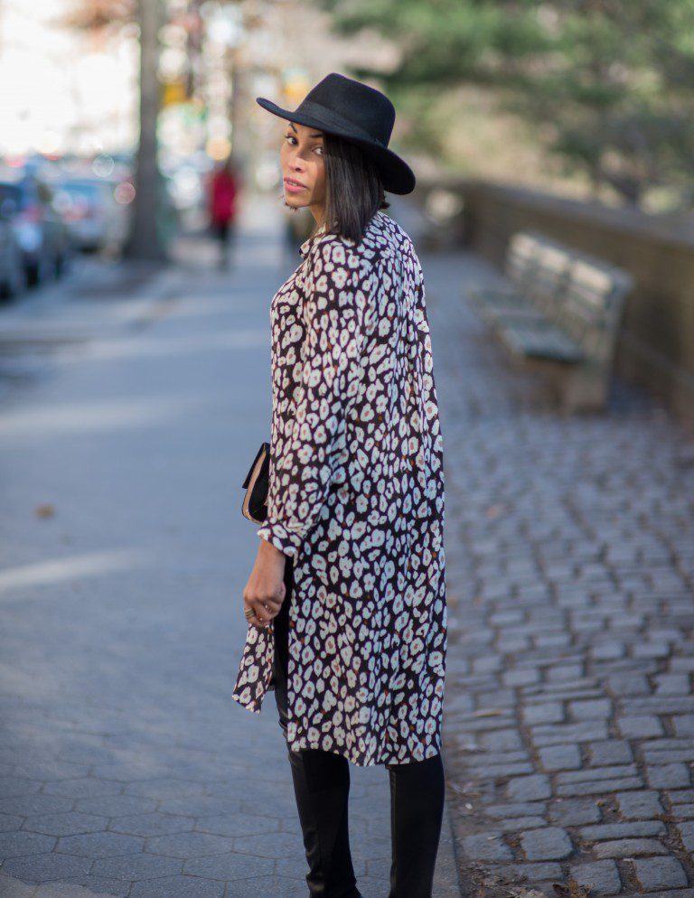 Woman in leopard print shirt and hat.