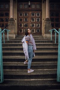 Woman in striped shirt on steps.