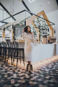 Woman in white dress at coffee shop.