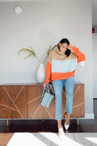 Woman in striped sweater and white heels.