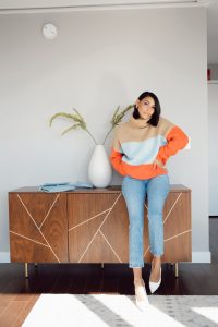 Woman in striped sweater and white heels.