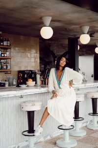 Woman in white dress at bar.