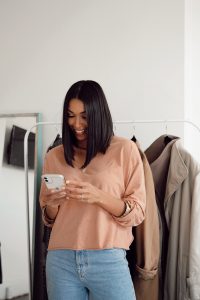 Woman smiling, using smartphone.